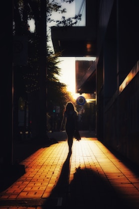 A silhouette walks towards the evening sunlight.