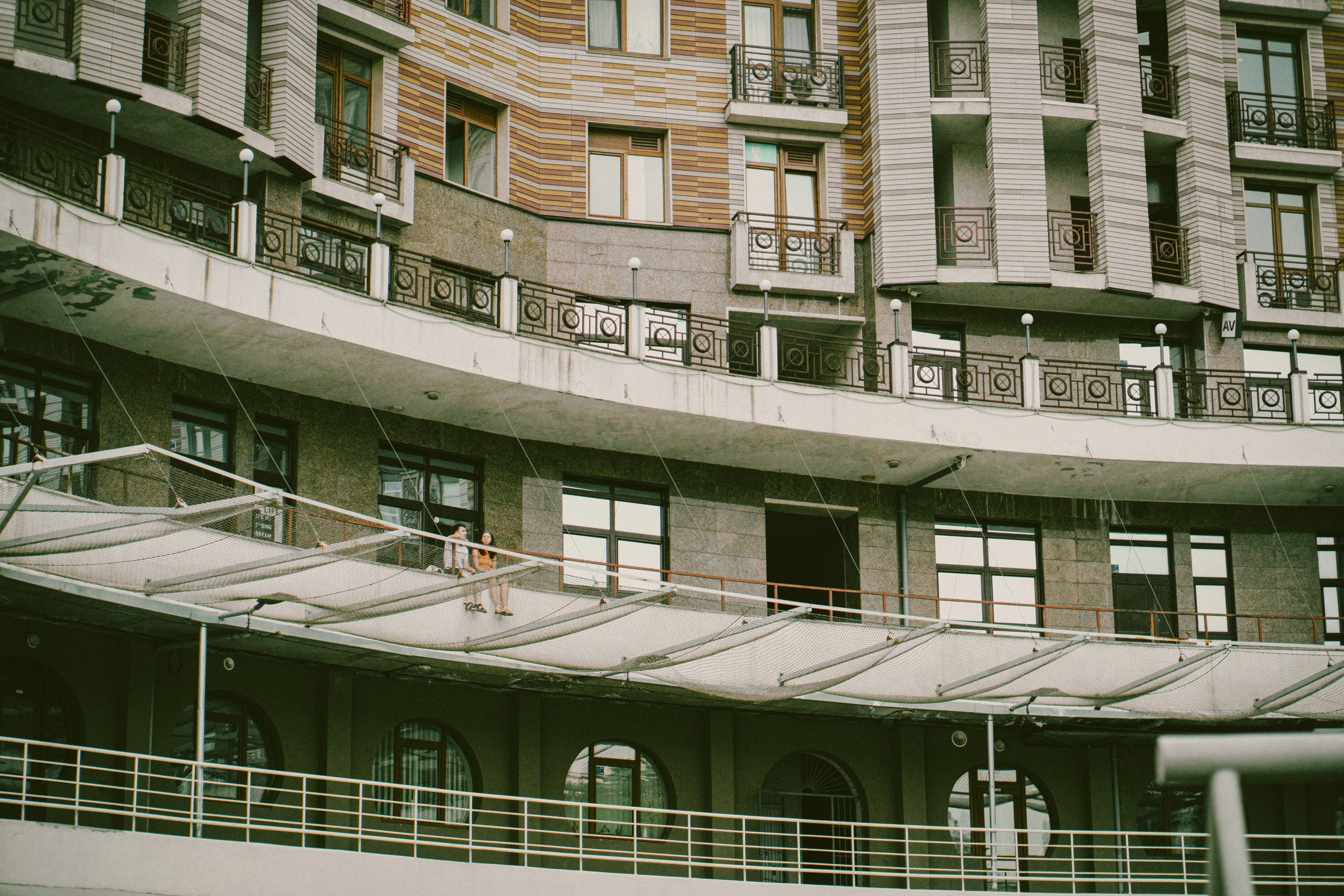People working on a curved building's balcony