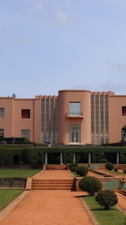 A pink building with terraced gardens and paths.