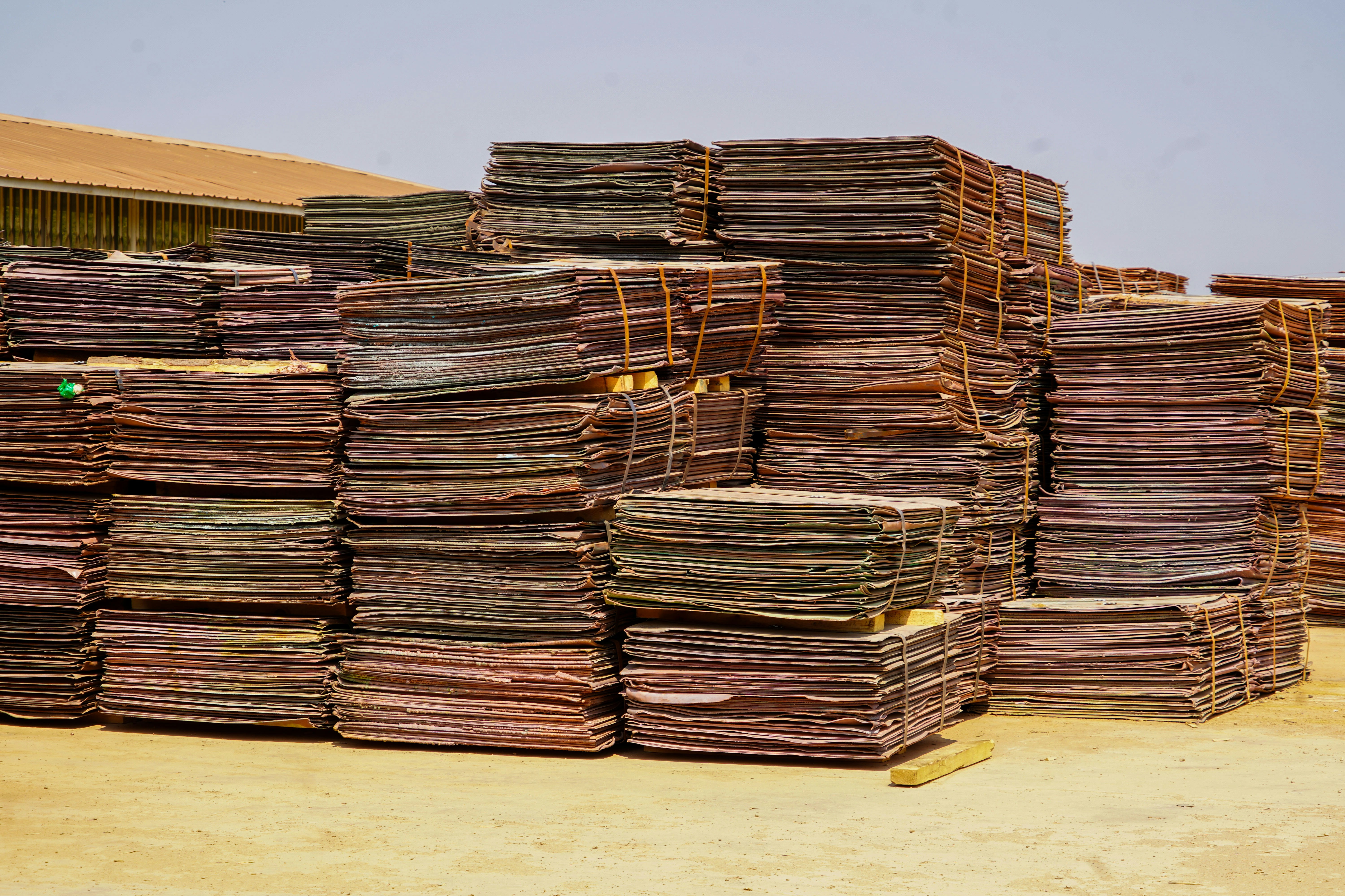 Stacks of copper sheets are bundled together.