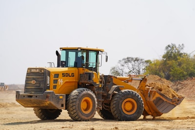 A yellow loader is moving earth on a construction site.
