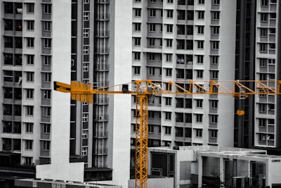 A construction crane stands before tall apartment buildings.