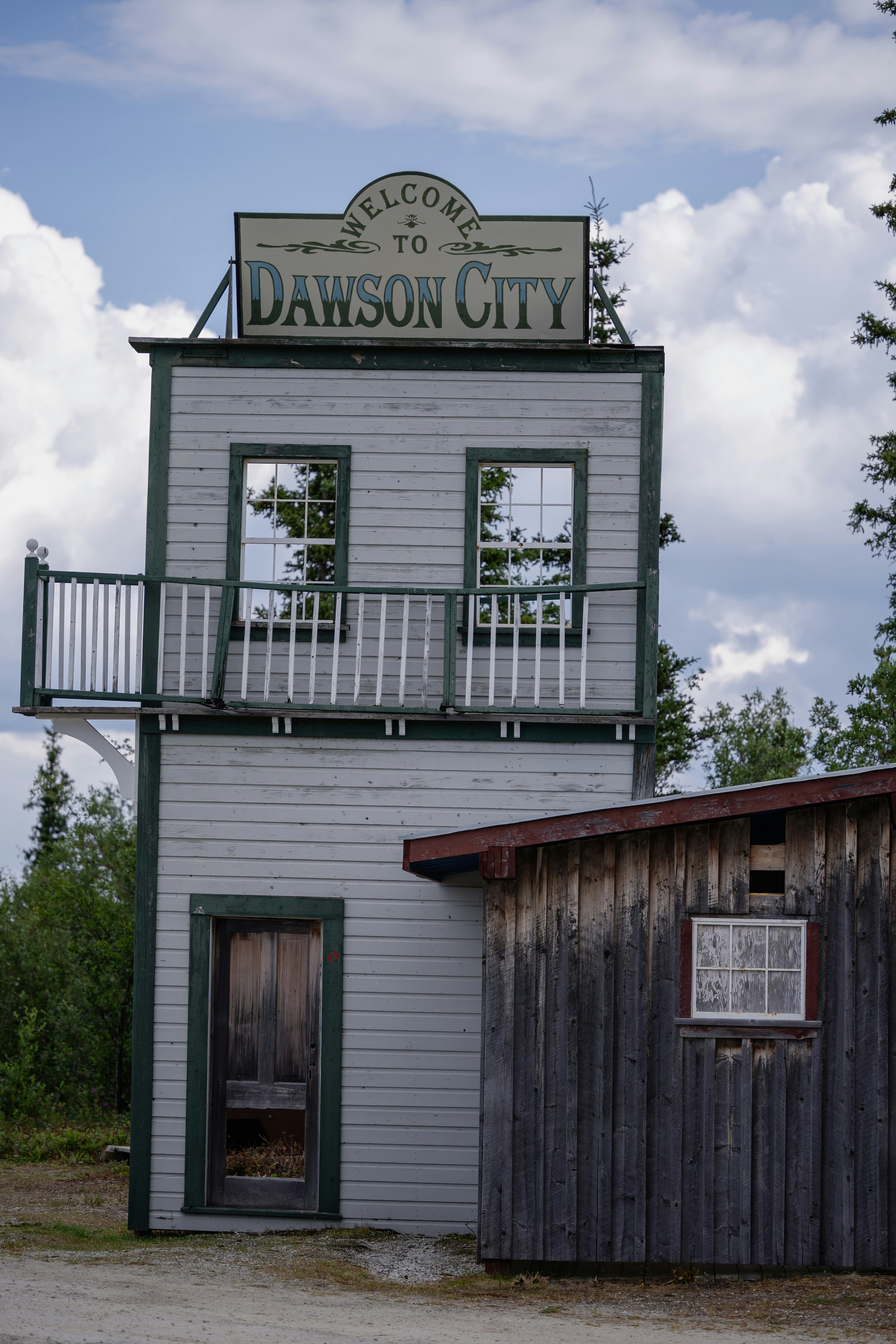 Welcome to dawson city sign atop a wooden building.