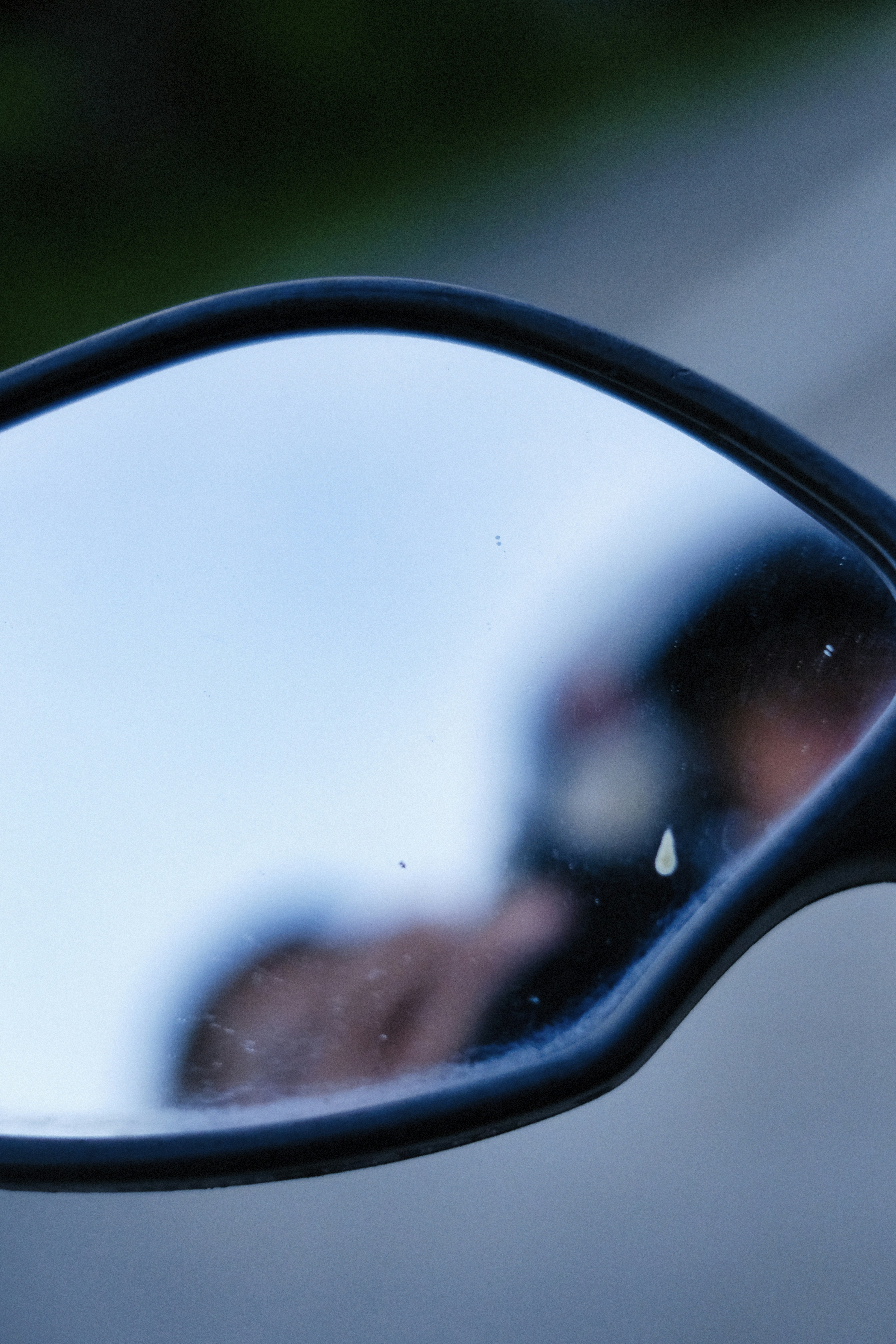 Um espelho de motocicleta reflete a imagem do motociclista.