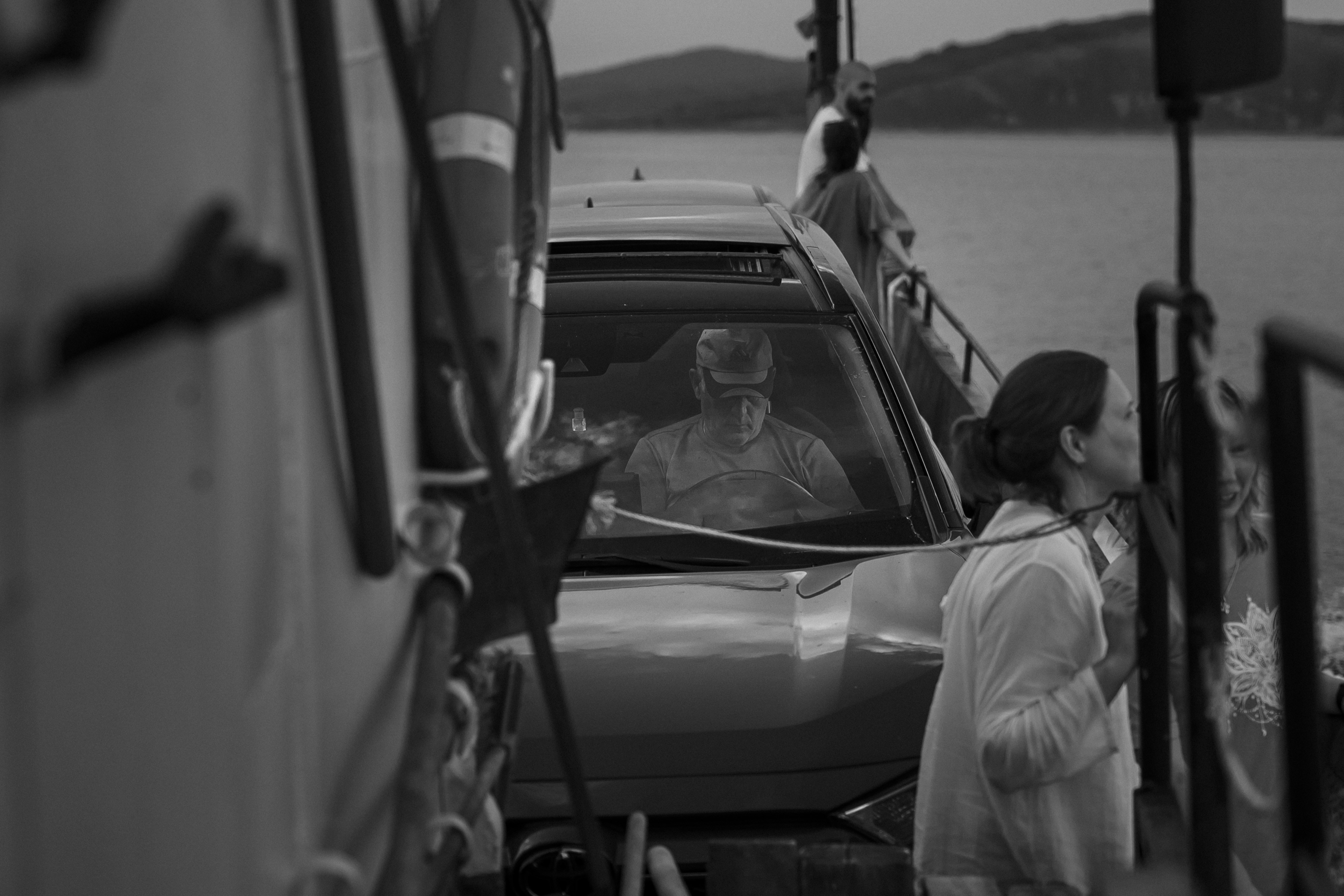People ride on a ferry with a car.