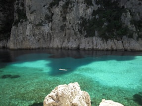 Clear turquoise water surrounds a rocky coastline.