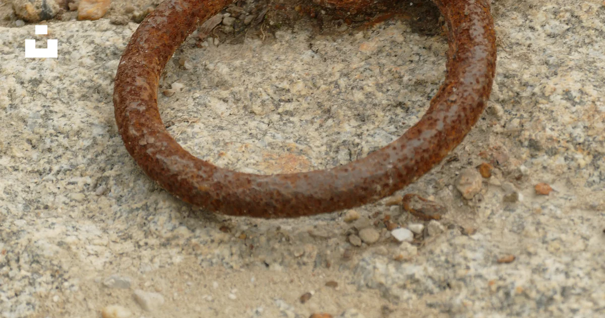 A rusty ring embedded in a stone surface. photo – Free Wallpaper Image ...
