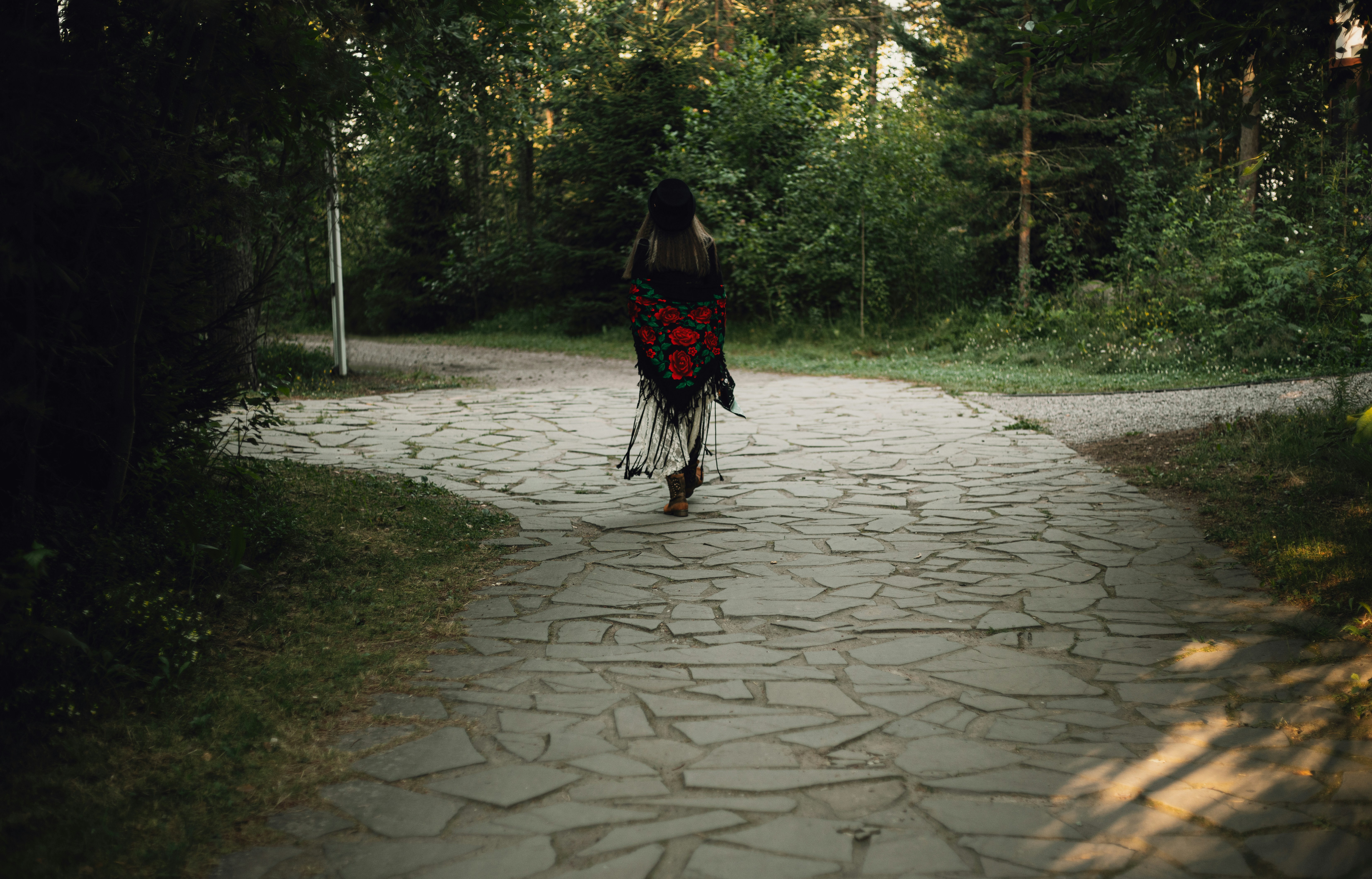 Woman walks away on a forest path.