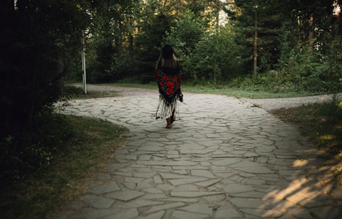 Woman walks away on a forest path.