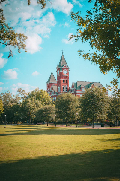 A historic building stands amidst lush trees.