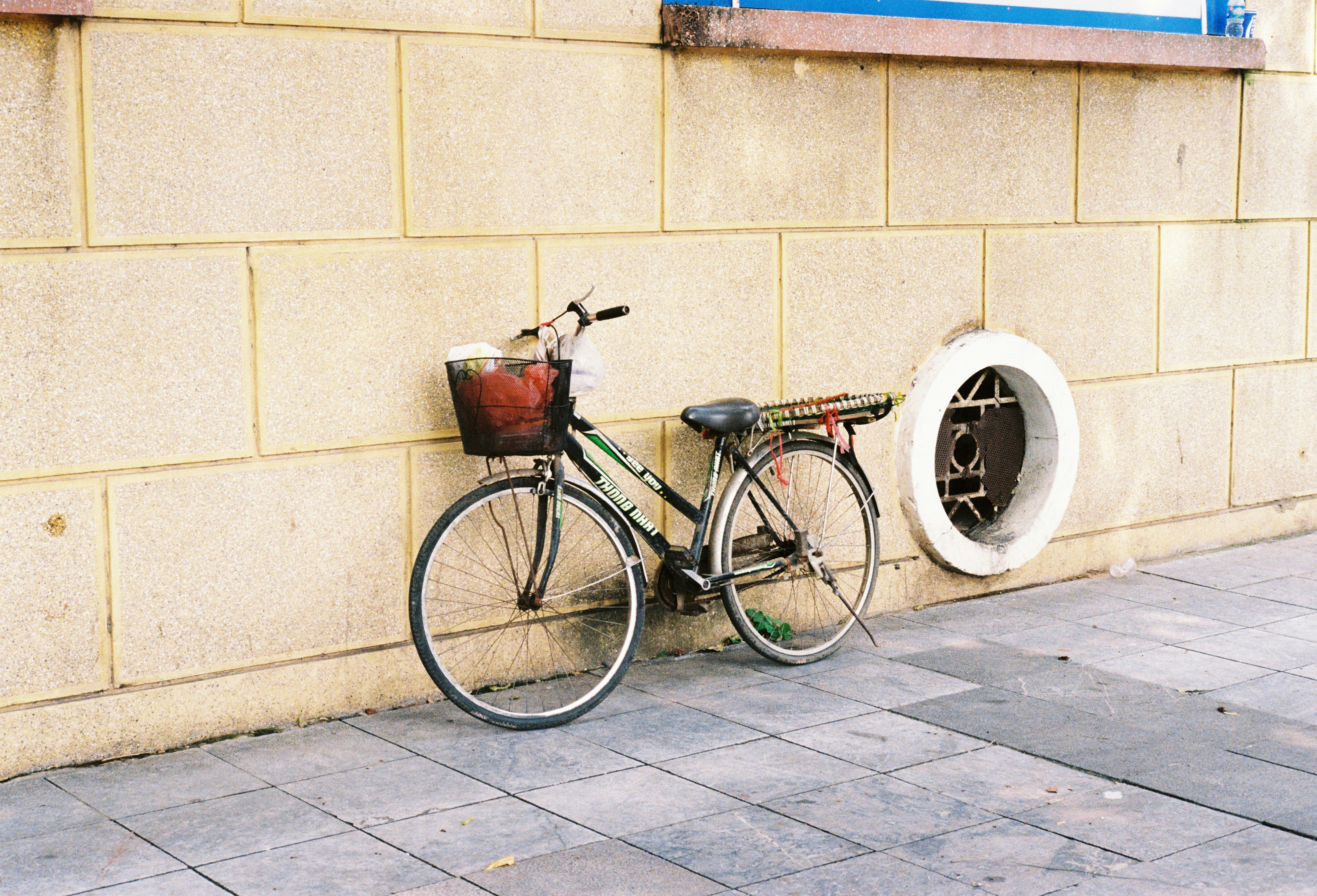 A bicycle is leaning against a wall.