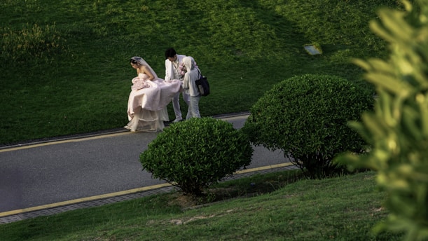 A couple walks in a lush green park.