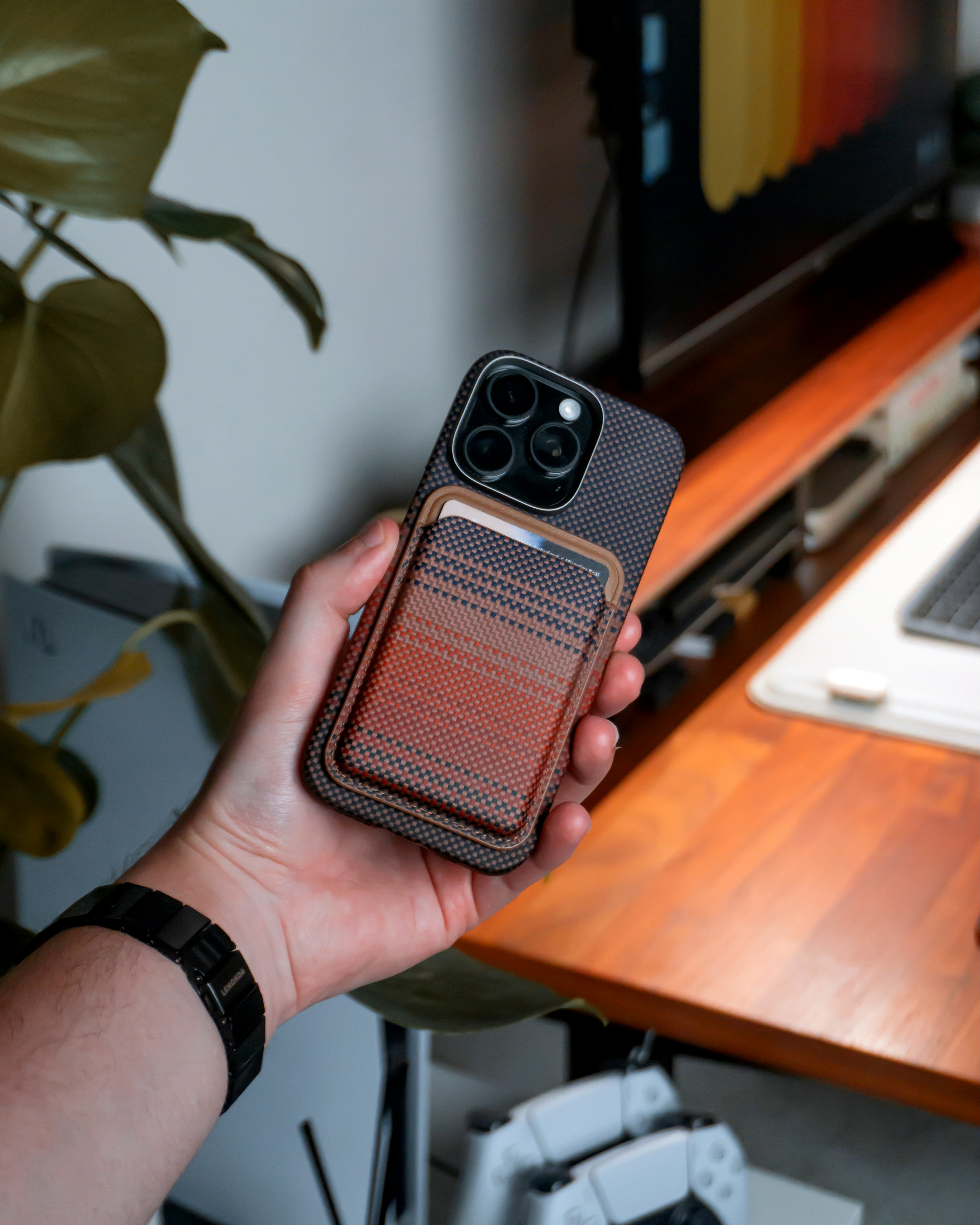 Hand holding a phone with a wallet case.