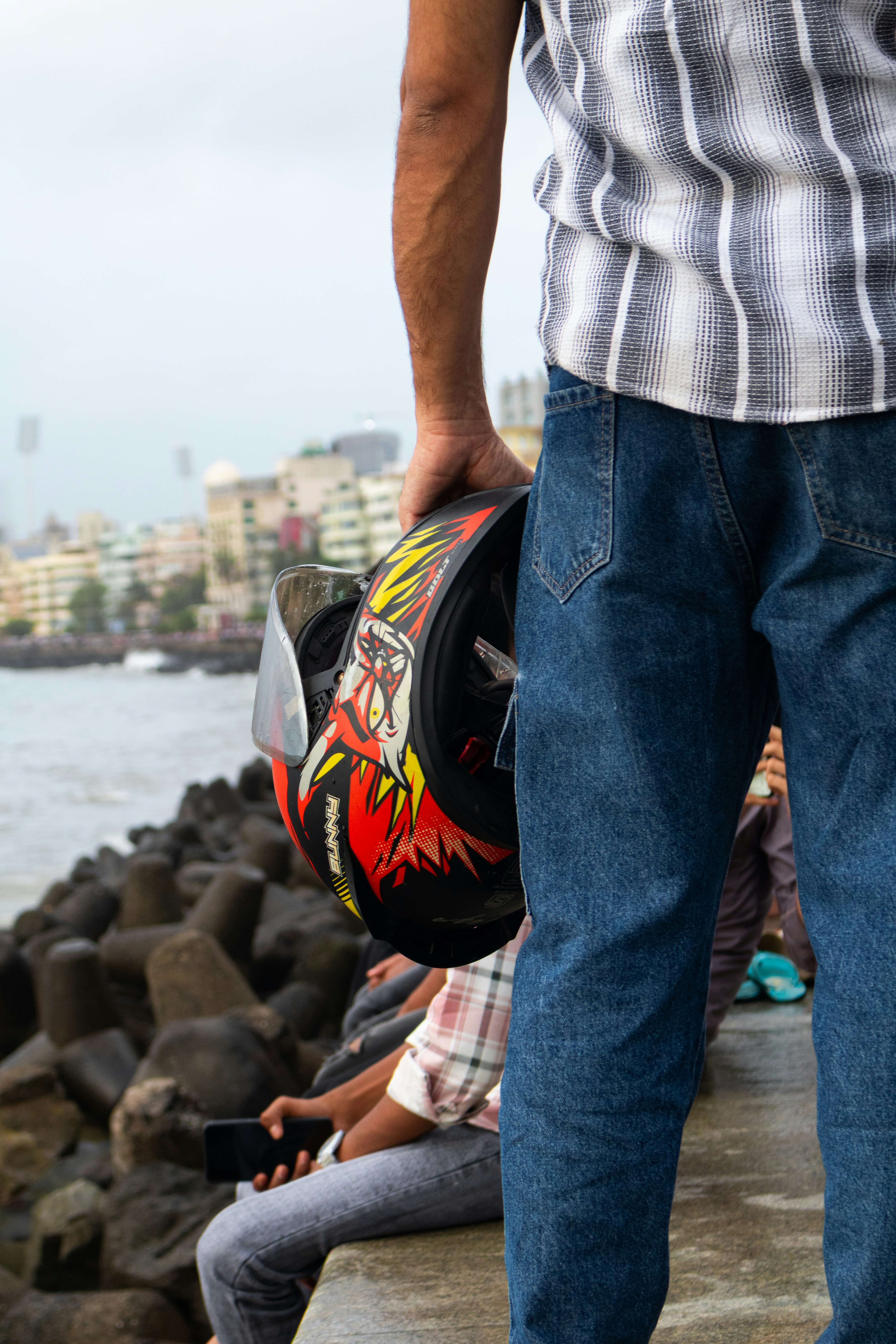 Man holds a helmet while gazing at the city.