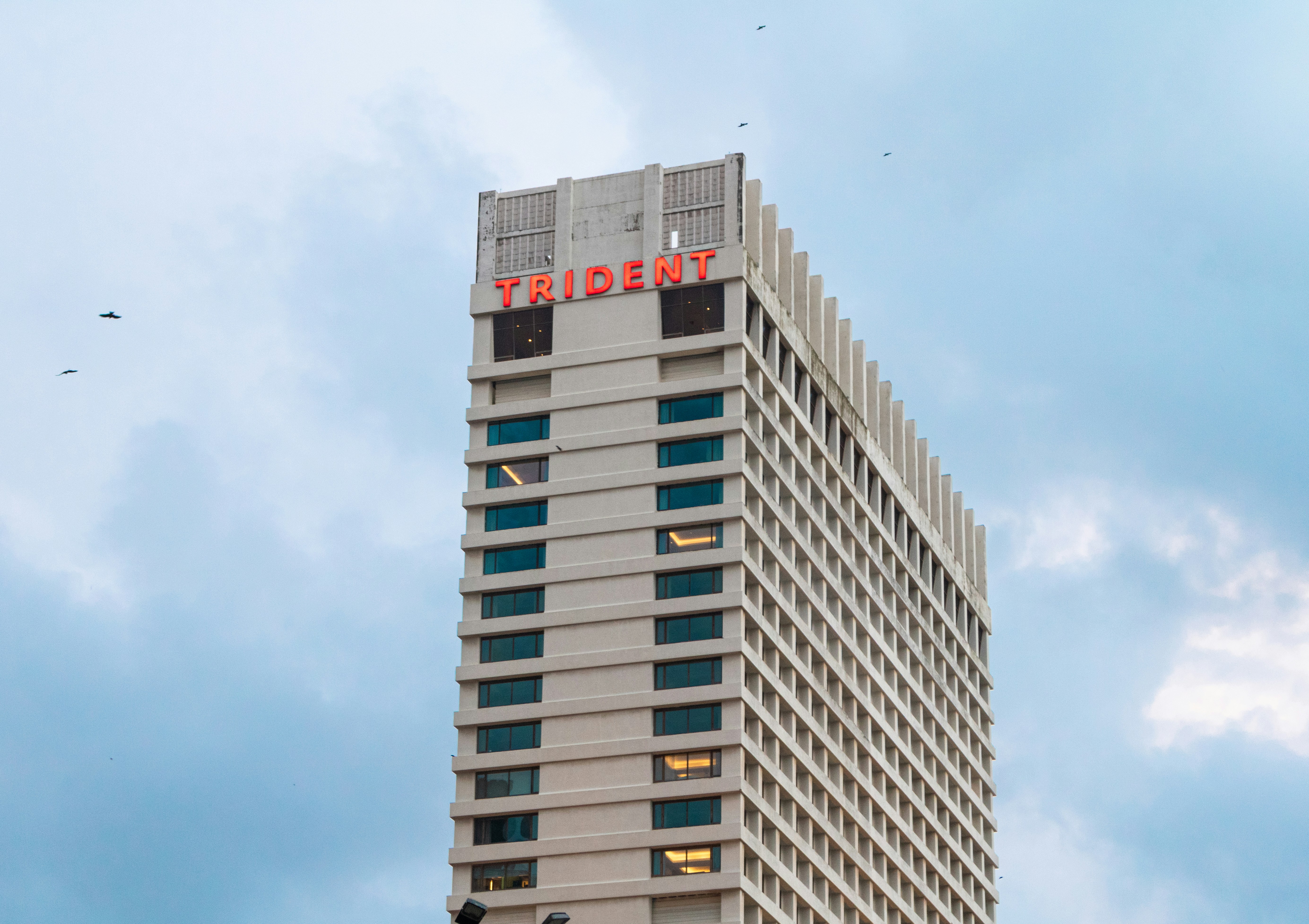 L'hotel del tridente si staglia contro un cielo nuvoloso.