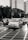 Cars and a motorcycle navigate a city intersection.