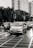 Cars and a motorcycle navigate a city intersection.
