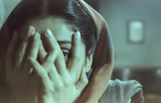 A woman covers her eyes.