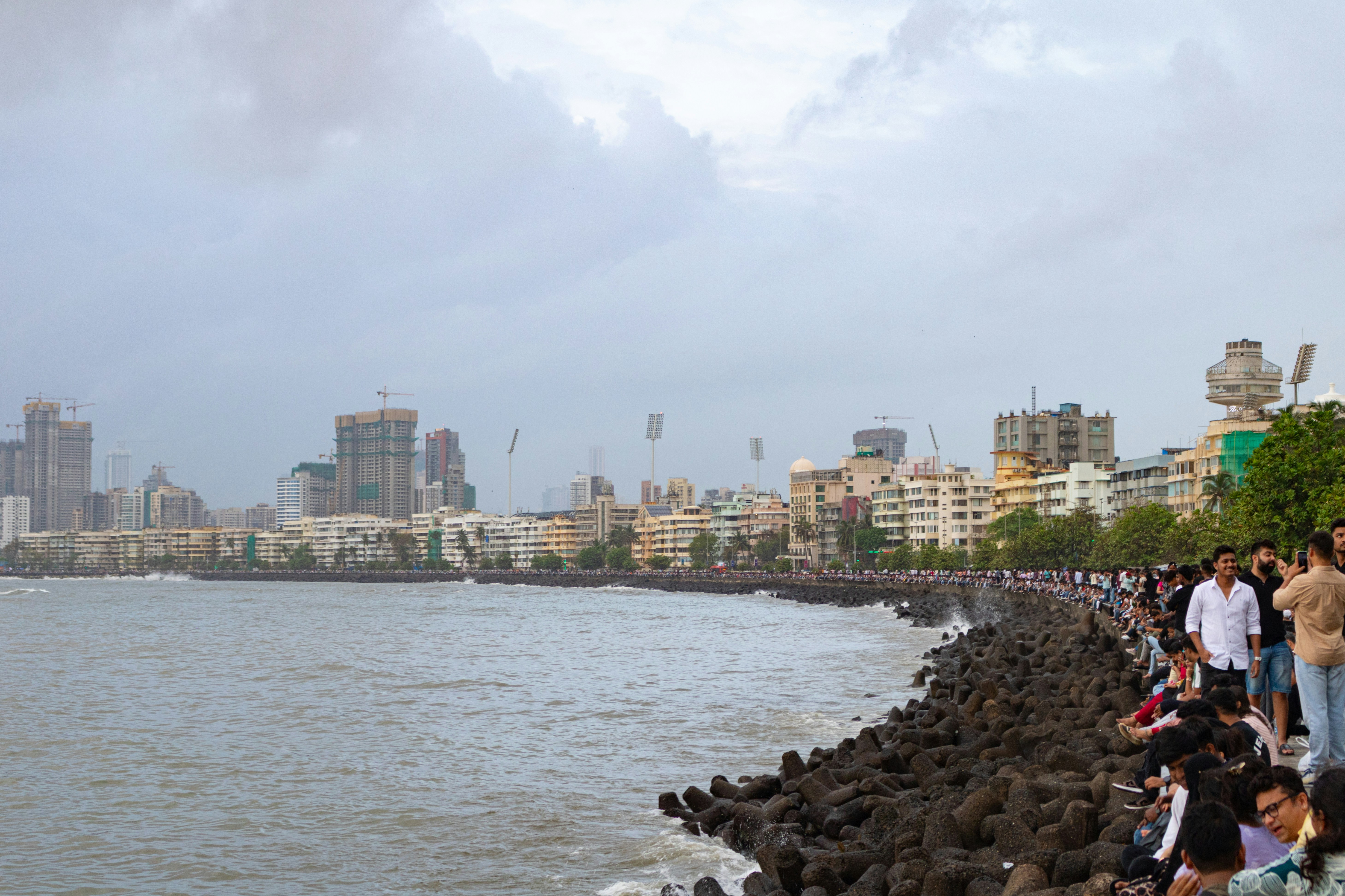 People walk along the mumbai coastline.