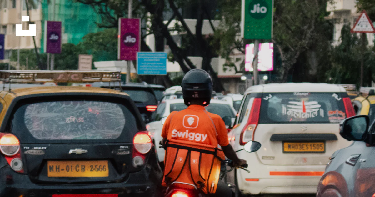 Swiggy Rider A swiggy rider navigating traffic on a motorbike. photo – Free Road ...