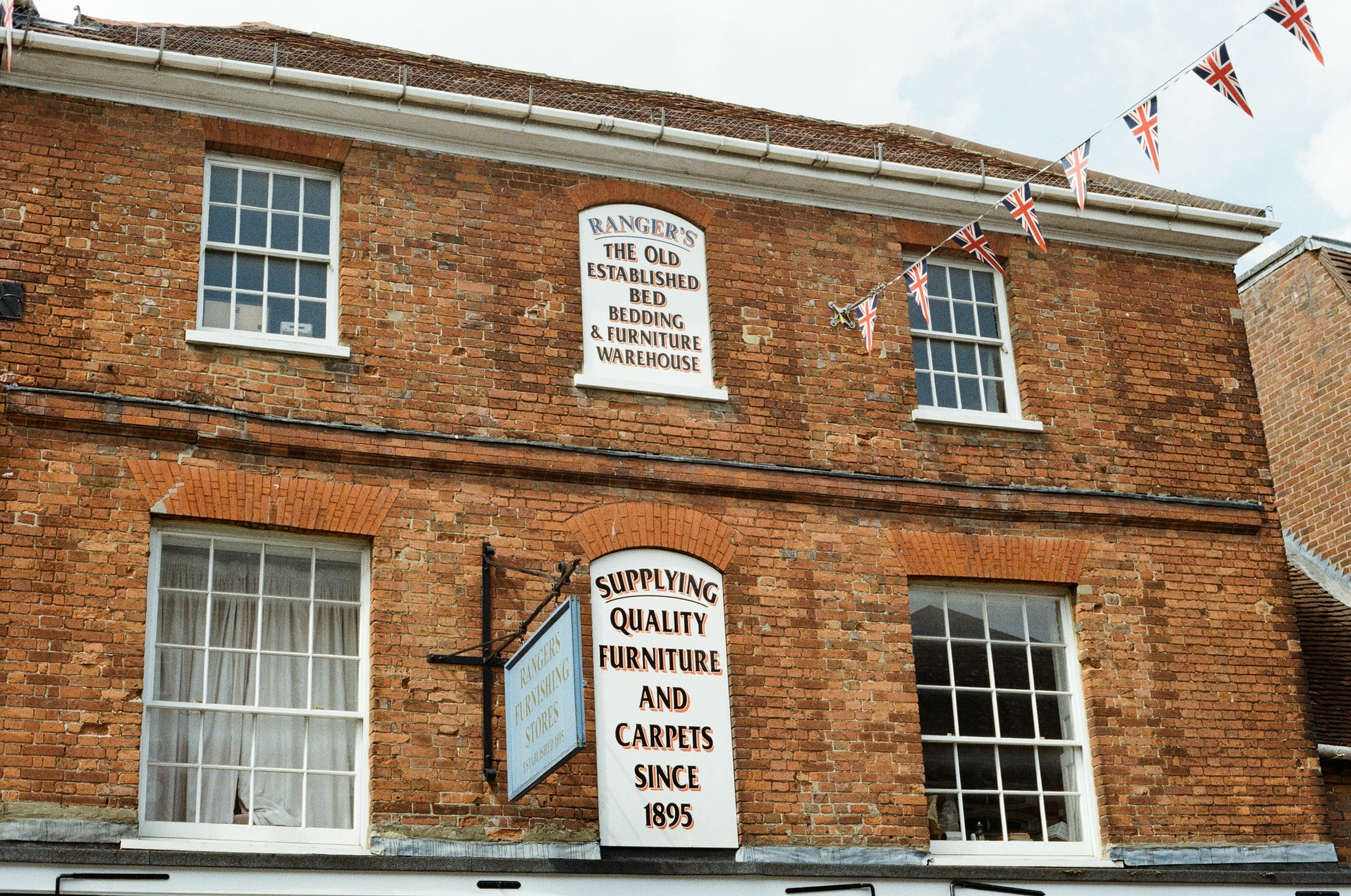 A brick building with signs for a furniture store.