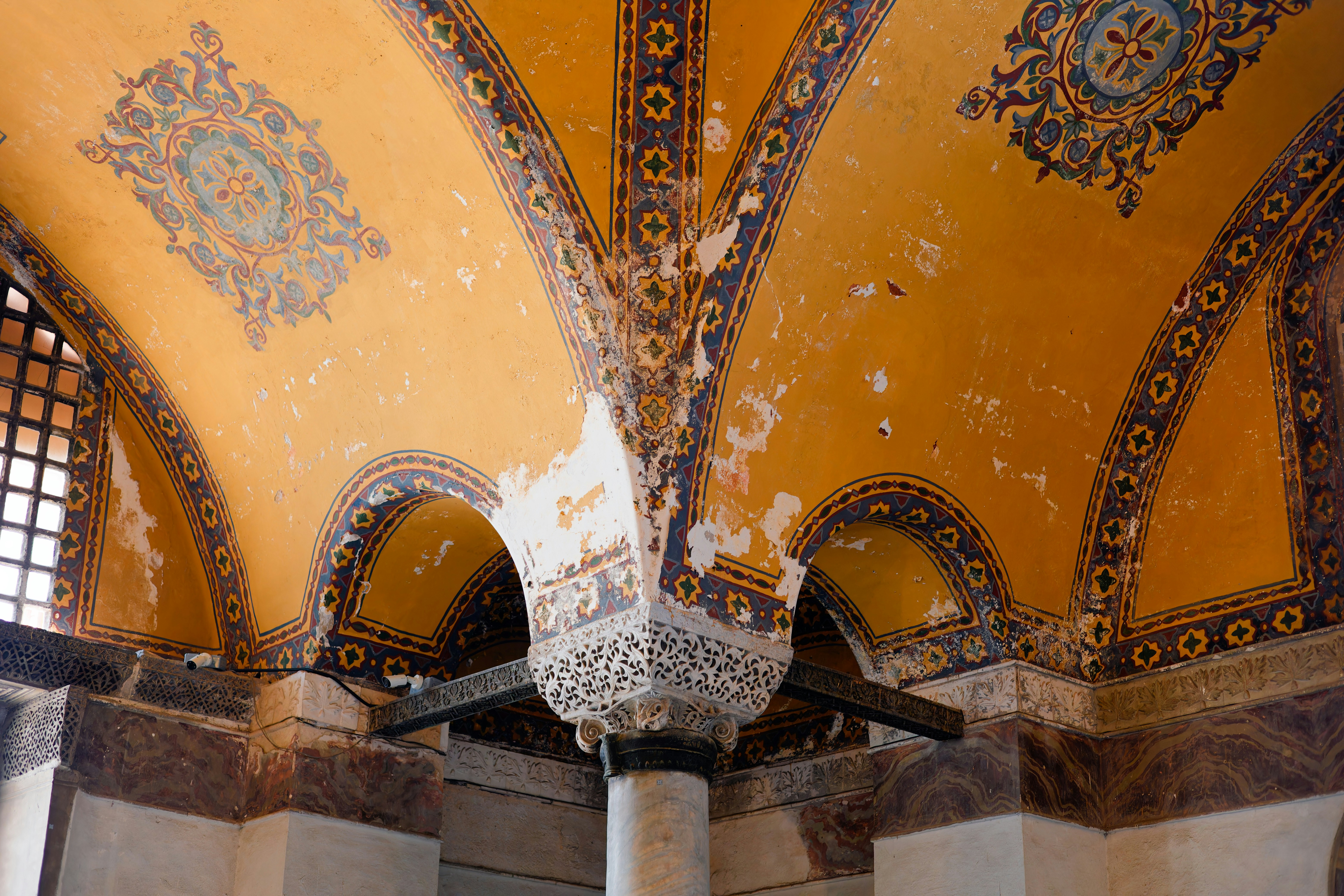 Aufwendige, gealterte Decke mit lebendigen, verblichenen Verzierungen.