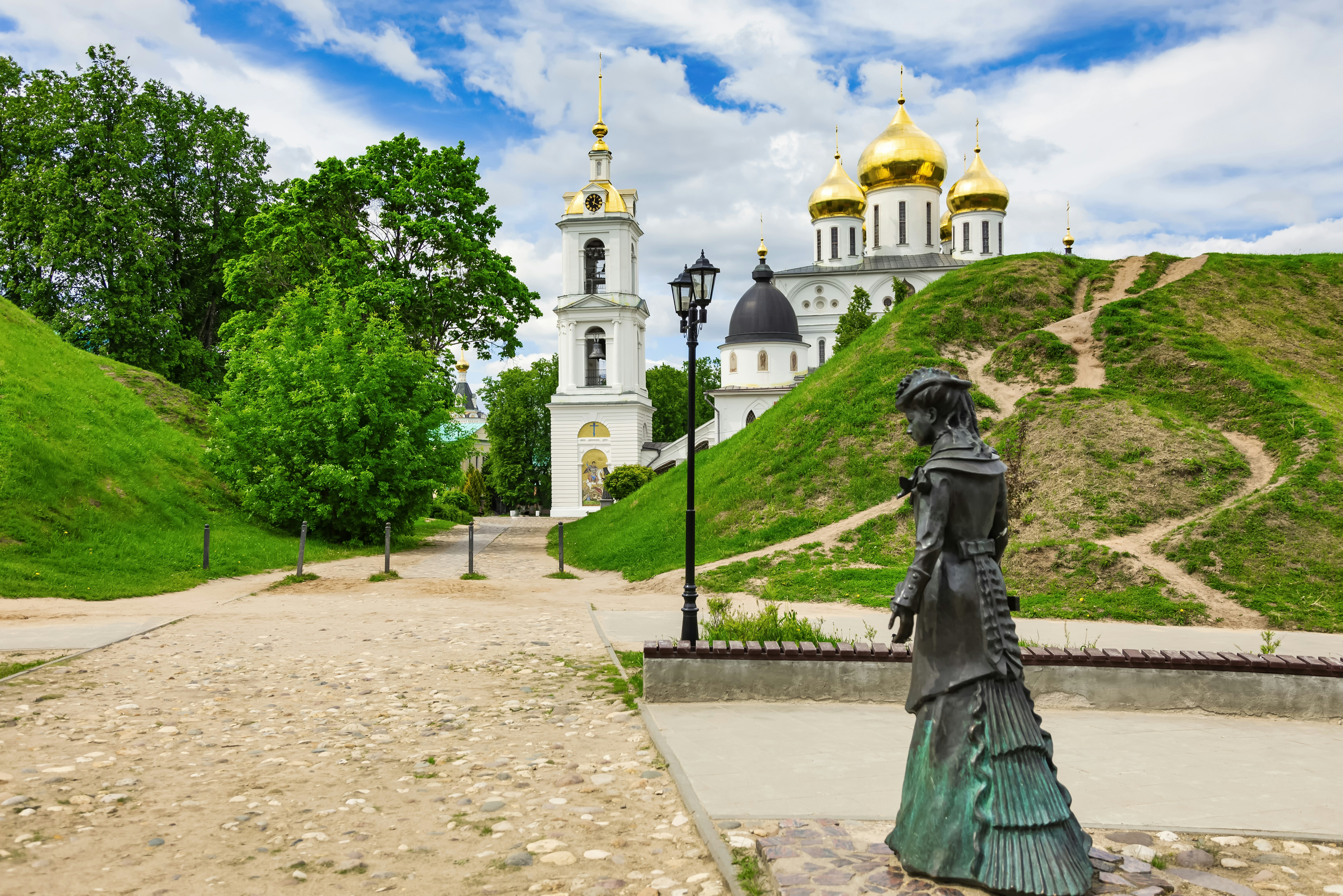 A statue stands with a cathedral in the background.