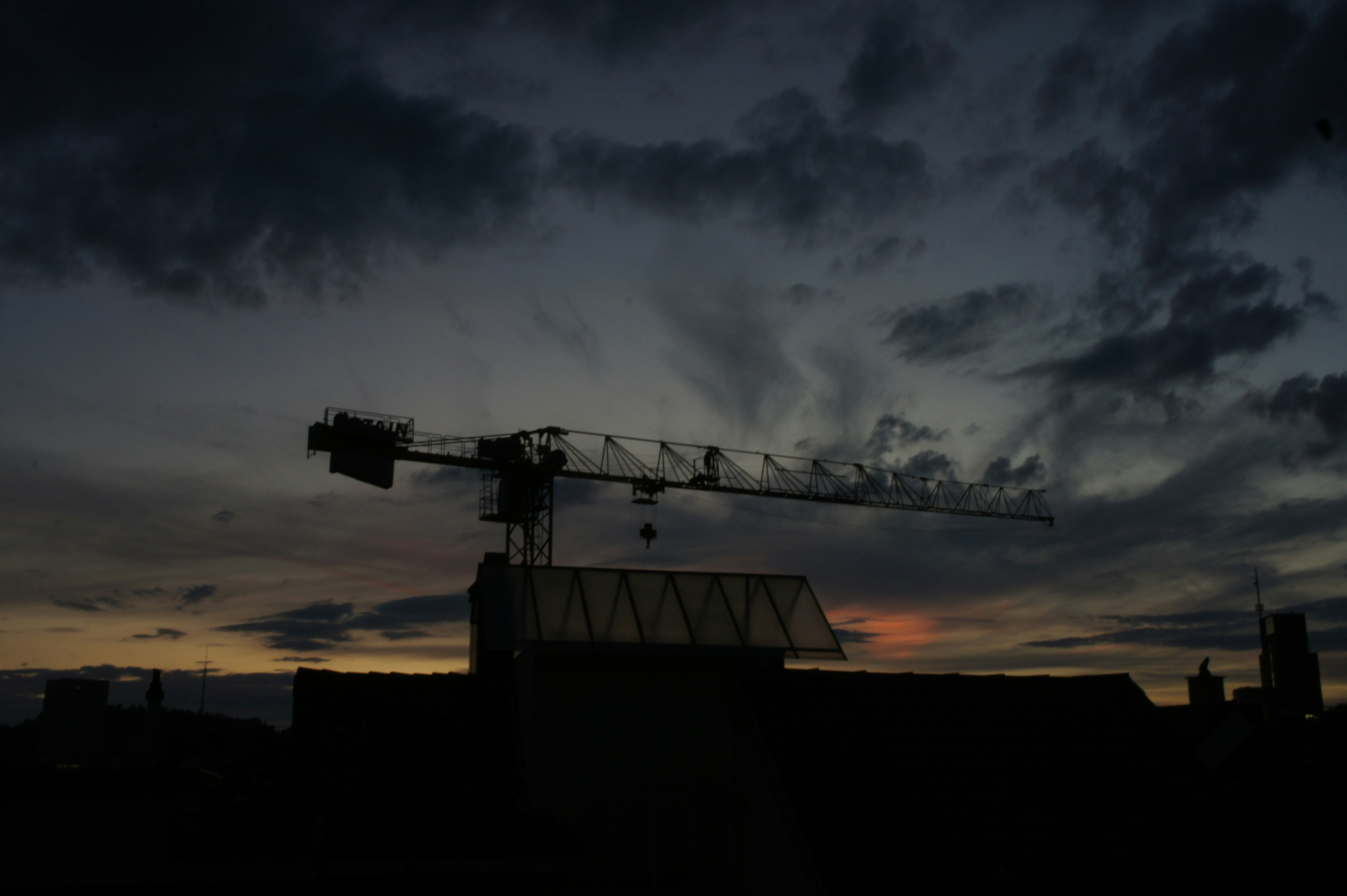 Grue de construction se découpant sur un ciel crépusculaire.