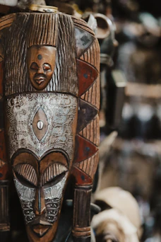An intricate, carved wooden african mask is shown.