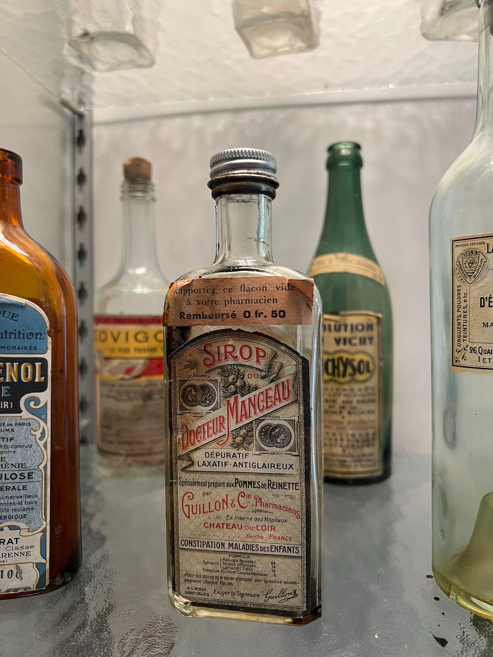 Vecchie boccette da farmacia con etichette esposte