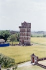 A tall tower stands in a field of yellow grass.