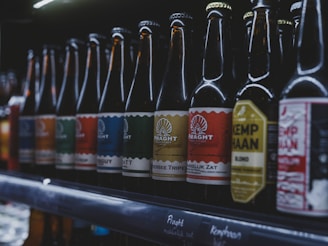 Bottles of beer are lined up on a shelf.
