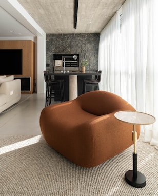 An orange chair sits in a stylish living room.