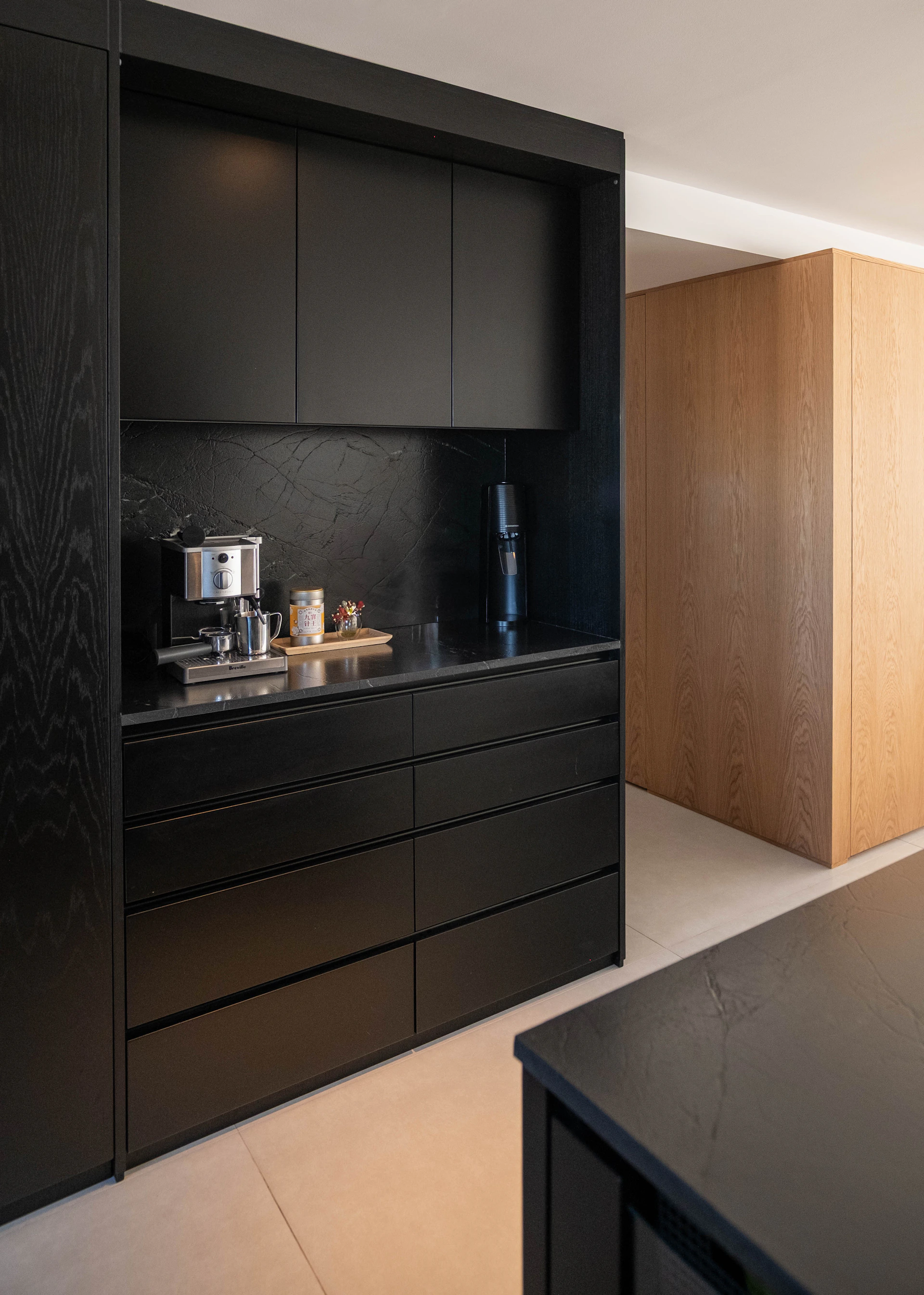 A modern kitchen with black cabinets and espresso machine