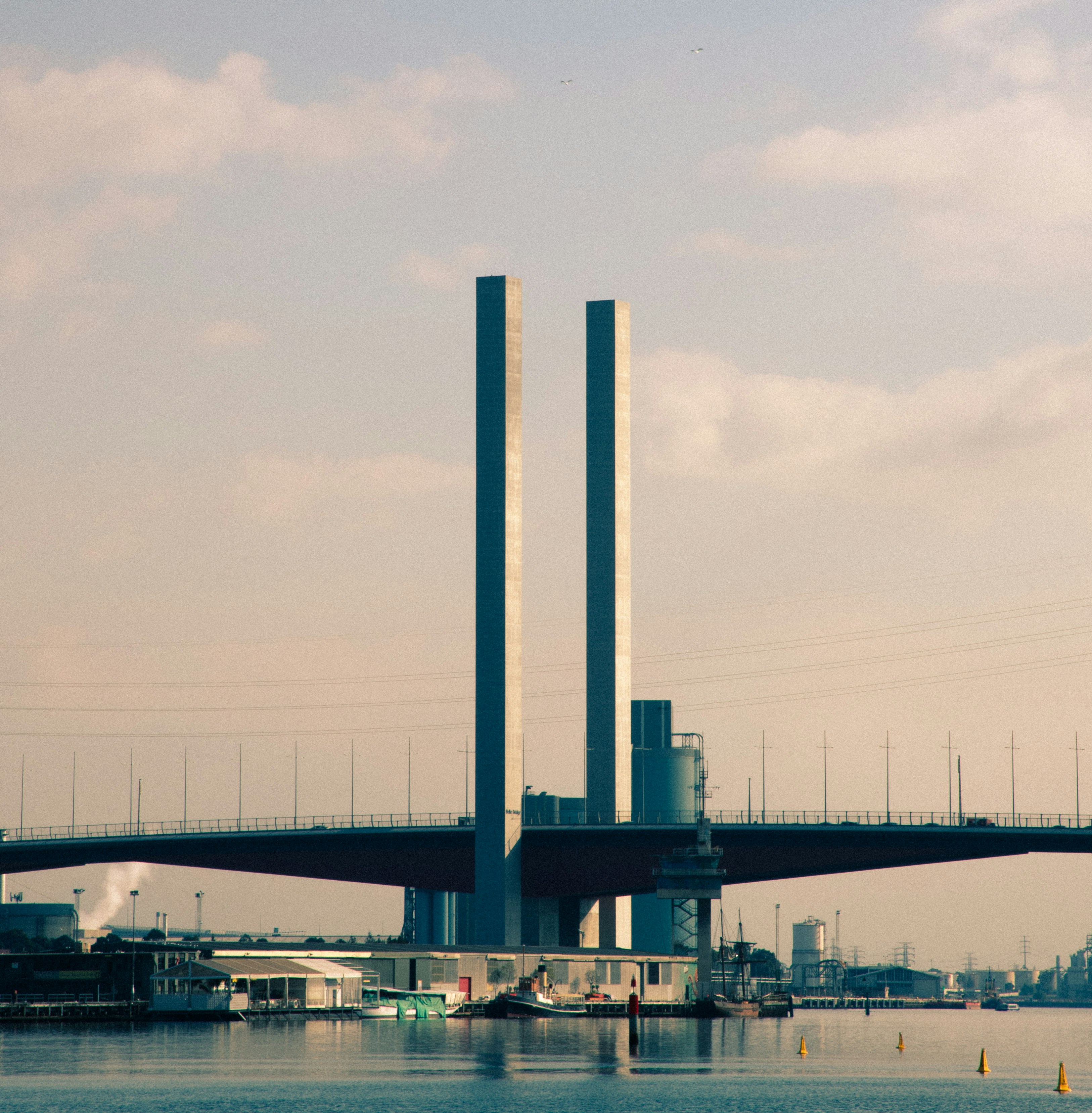 A modern bridge spans across a calm body of water.