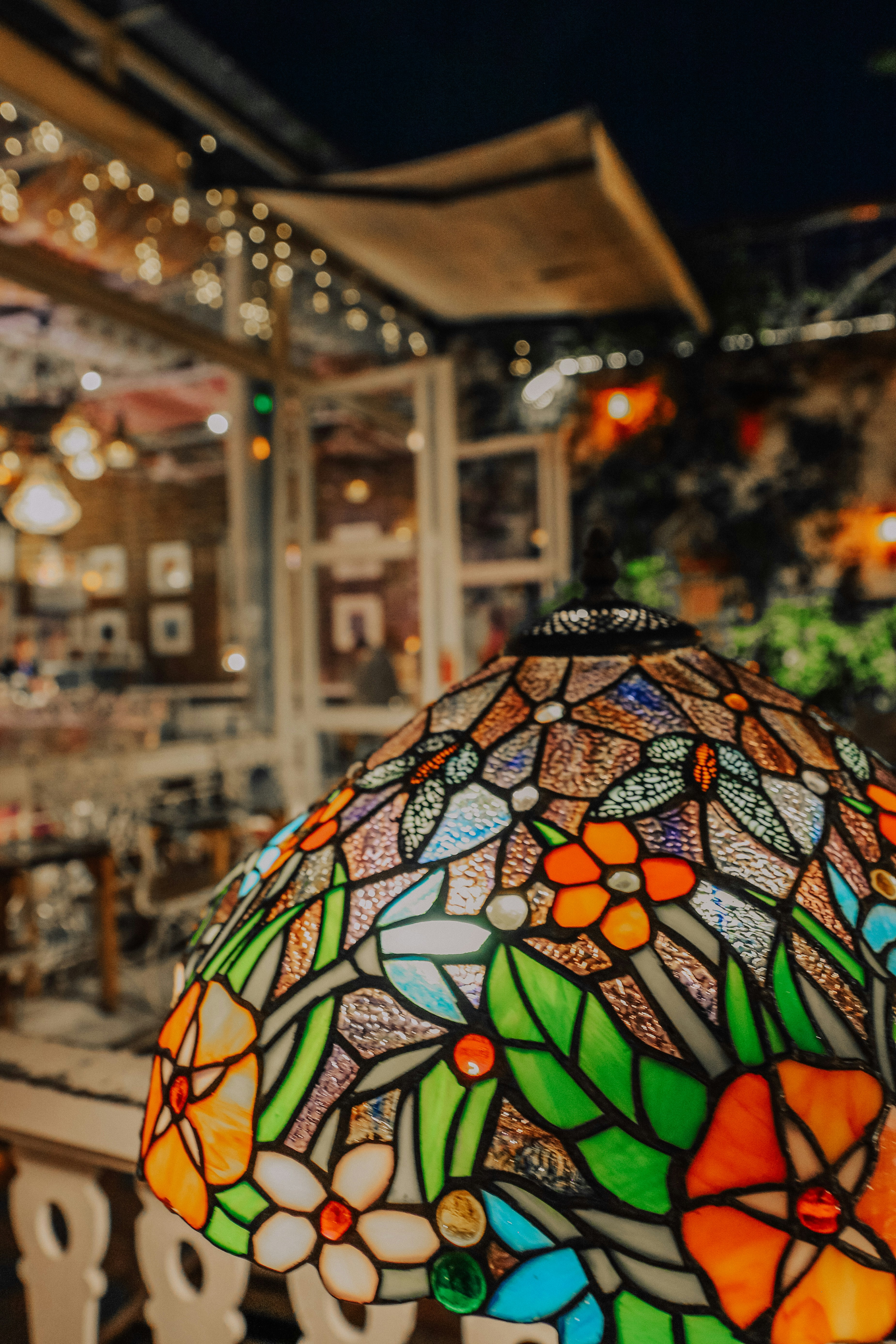 Eine Buntglaslampe erhellt eine nächtliche Szenerie.