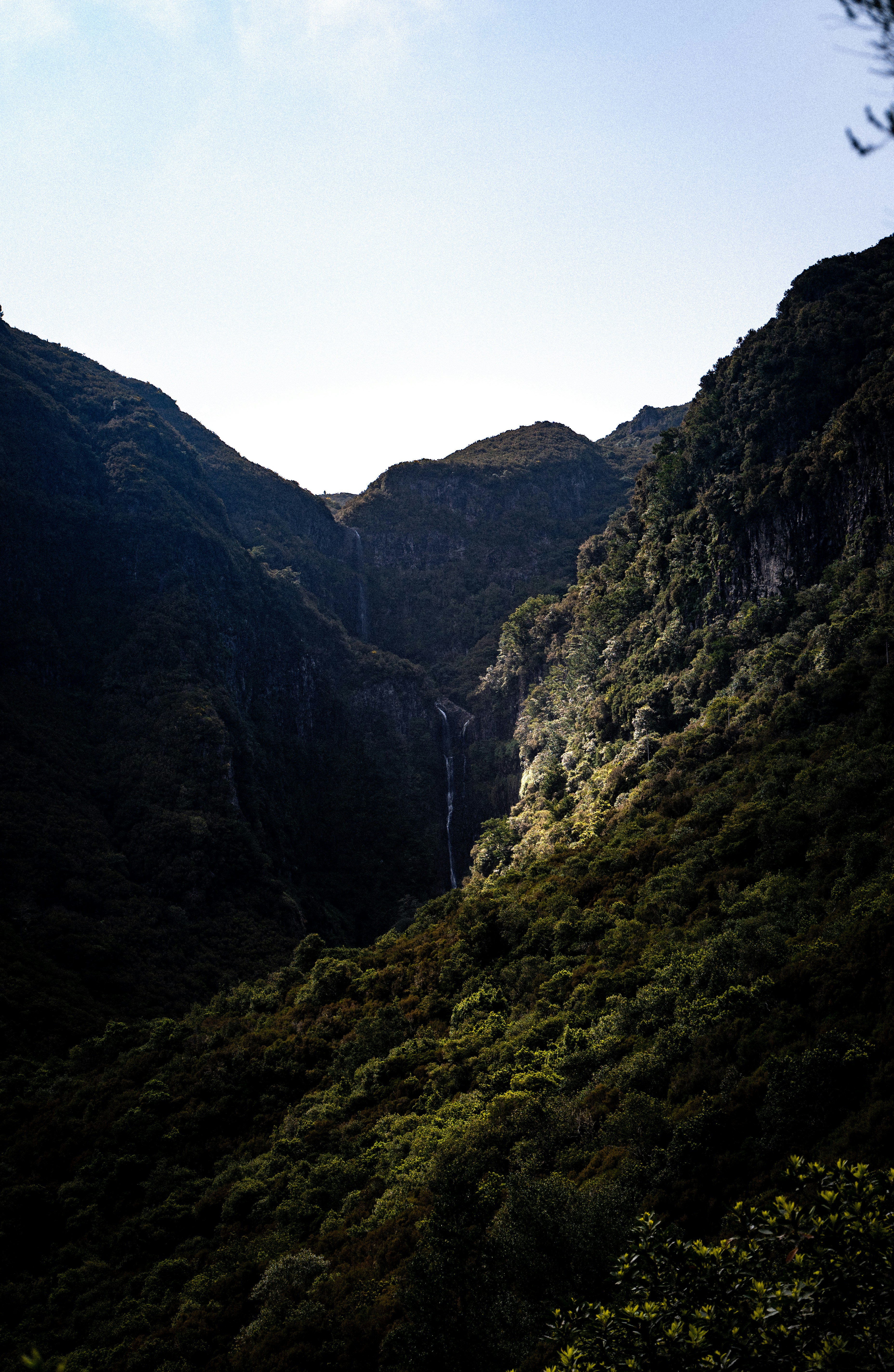 Mountains frame a waterfall cascading through the valley.