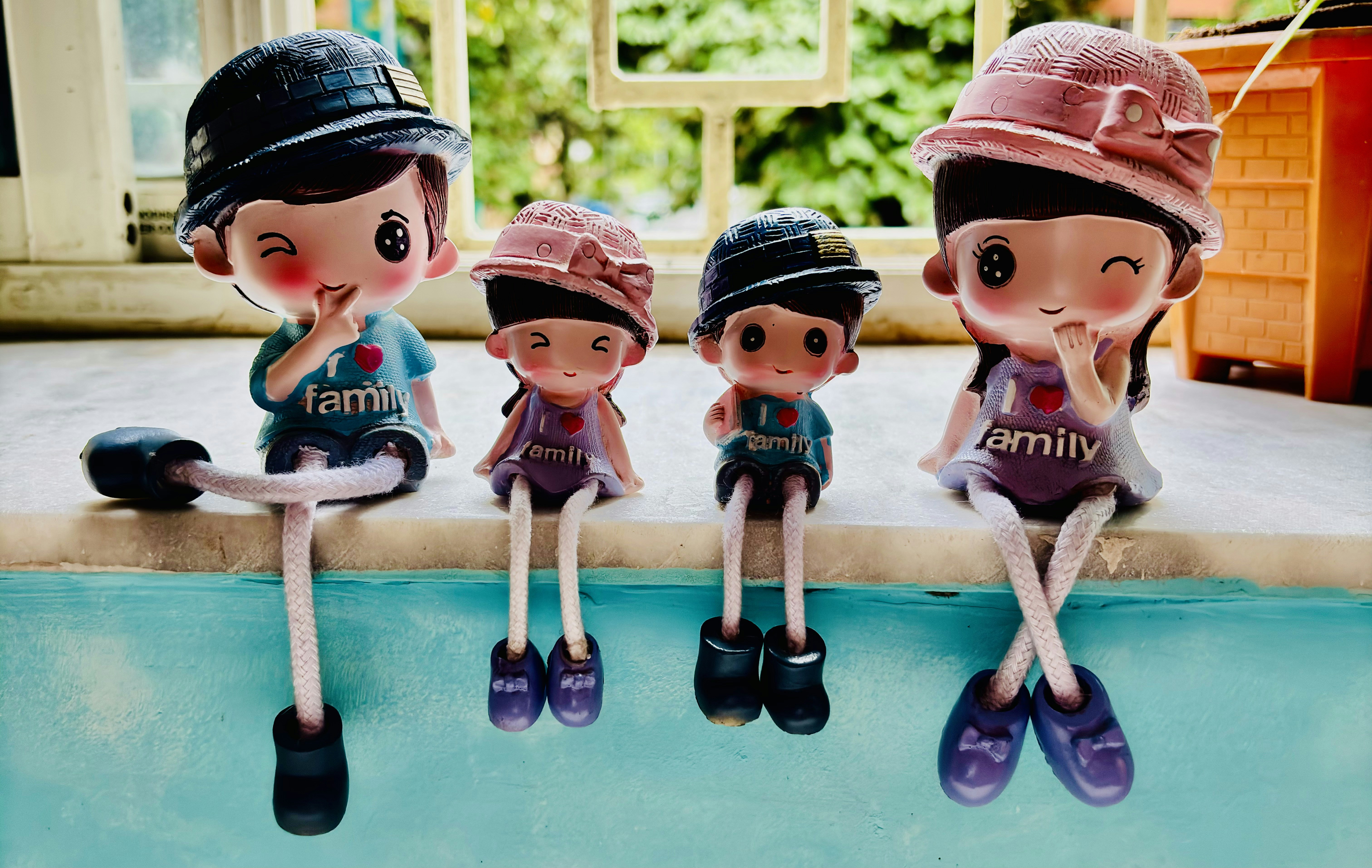Family figurines sit together on a window sill.