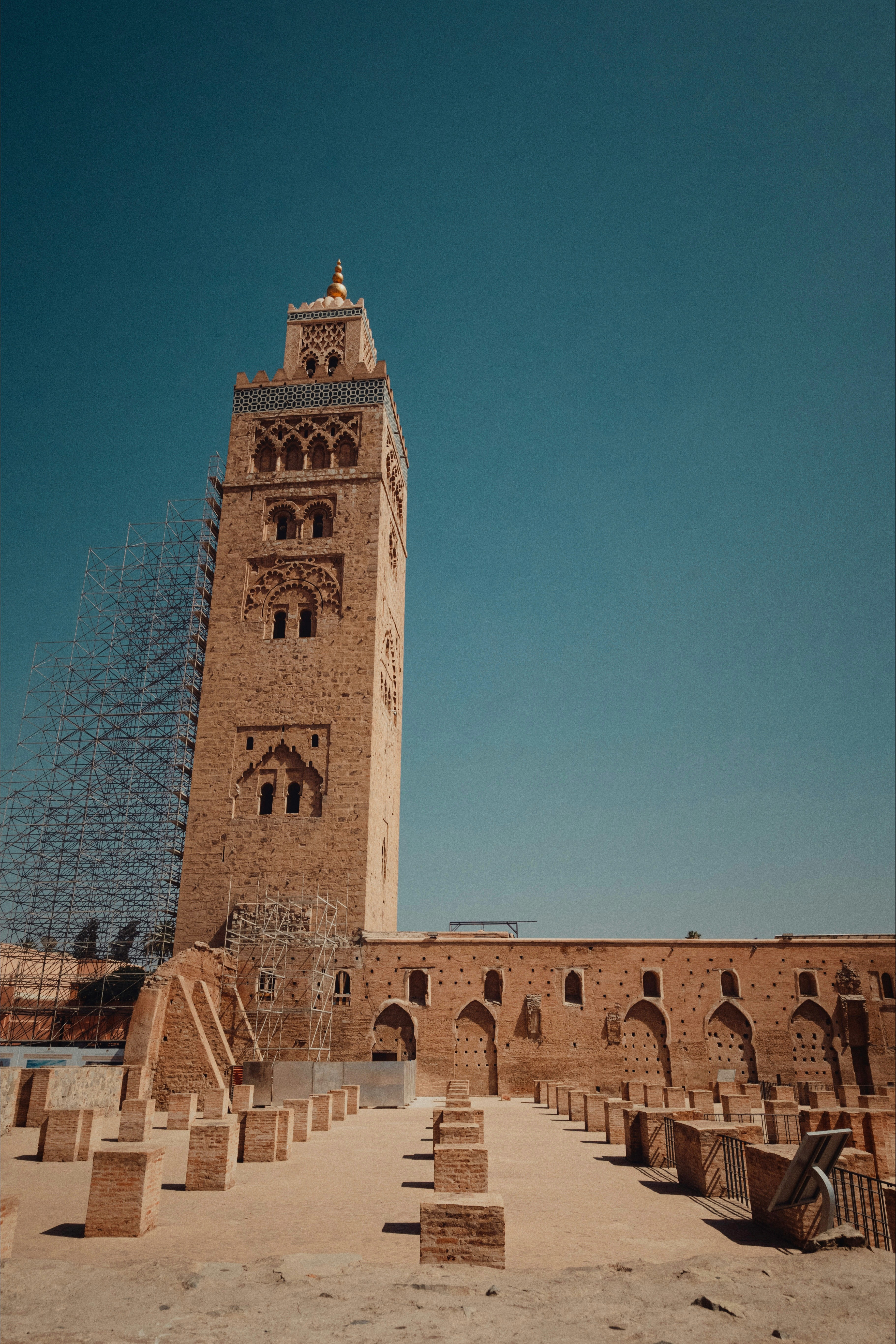 A tall mosque tower stands against a bright blue sky.