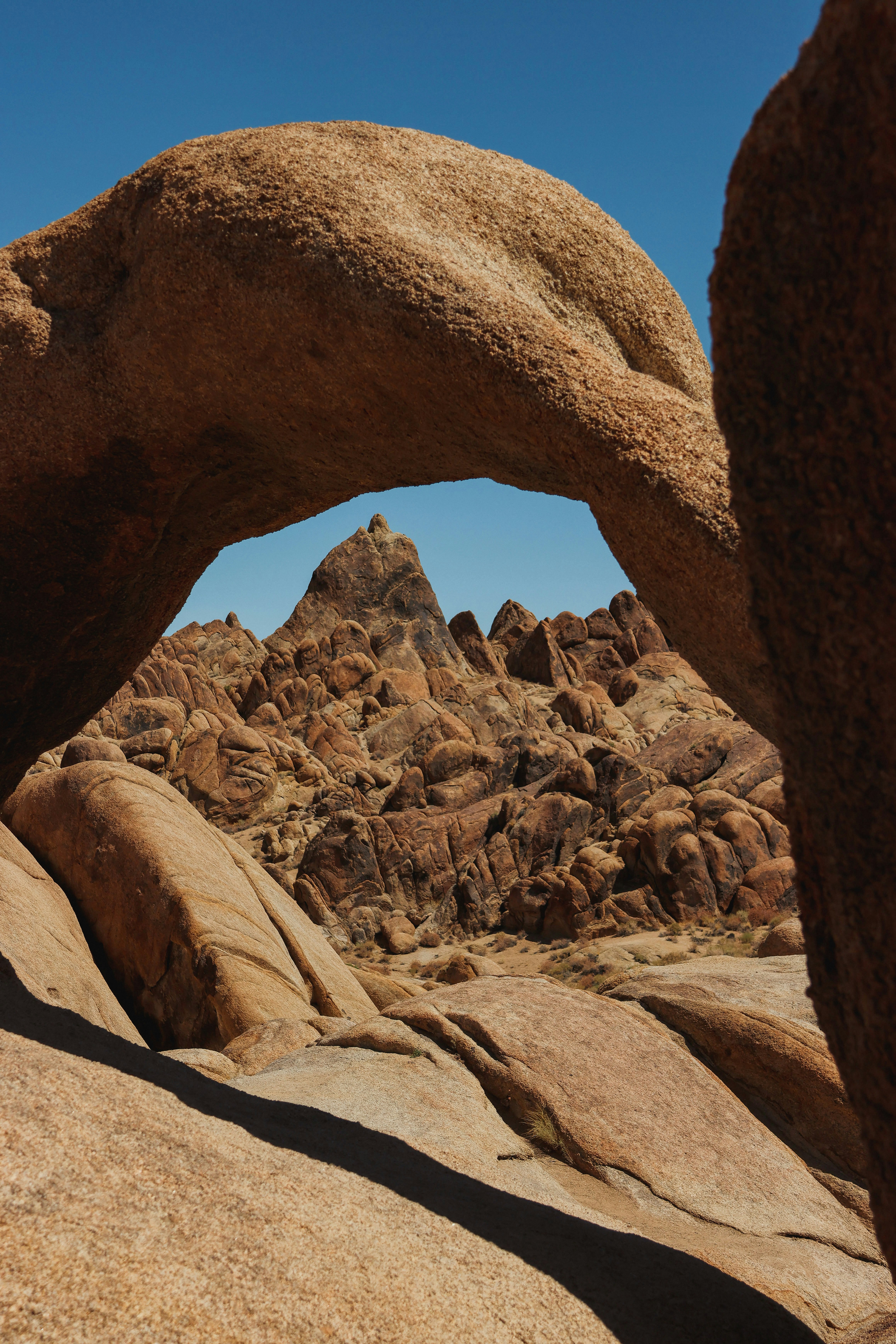 Un arco de roca natural enmarca un paisaje rocoso.
