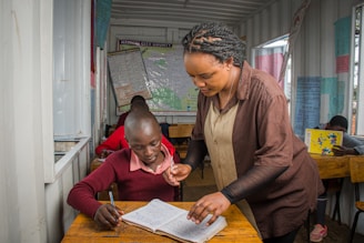 A teacher assists a student in a classroom.