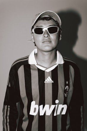 A person is wearing a soccer jersey and sunglasses.