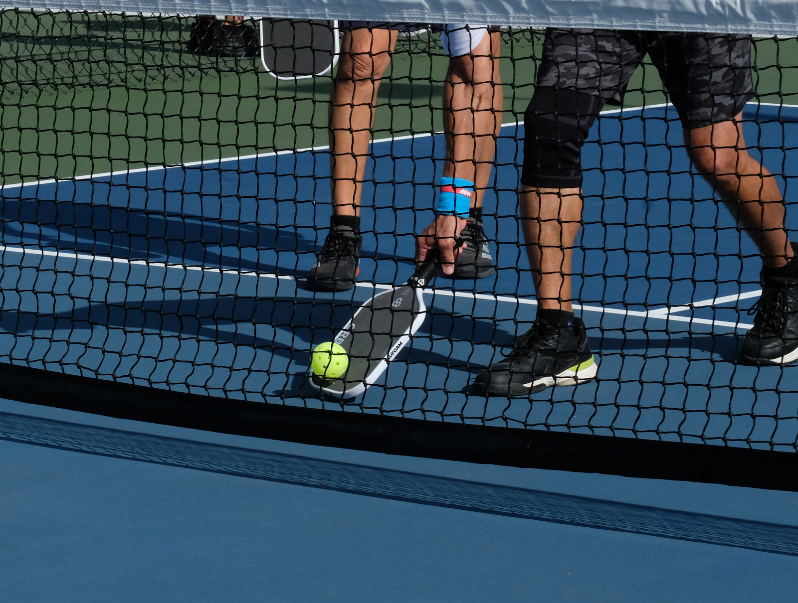 Two players trading volleys at the kitchen line on a Sunday morning