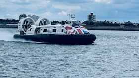 A hovercraft with a british flag is cruising.