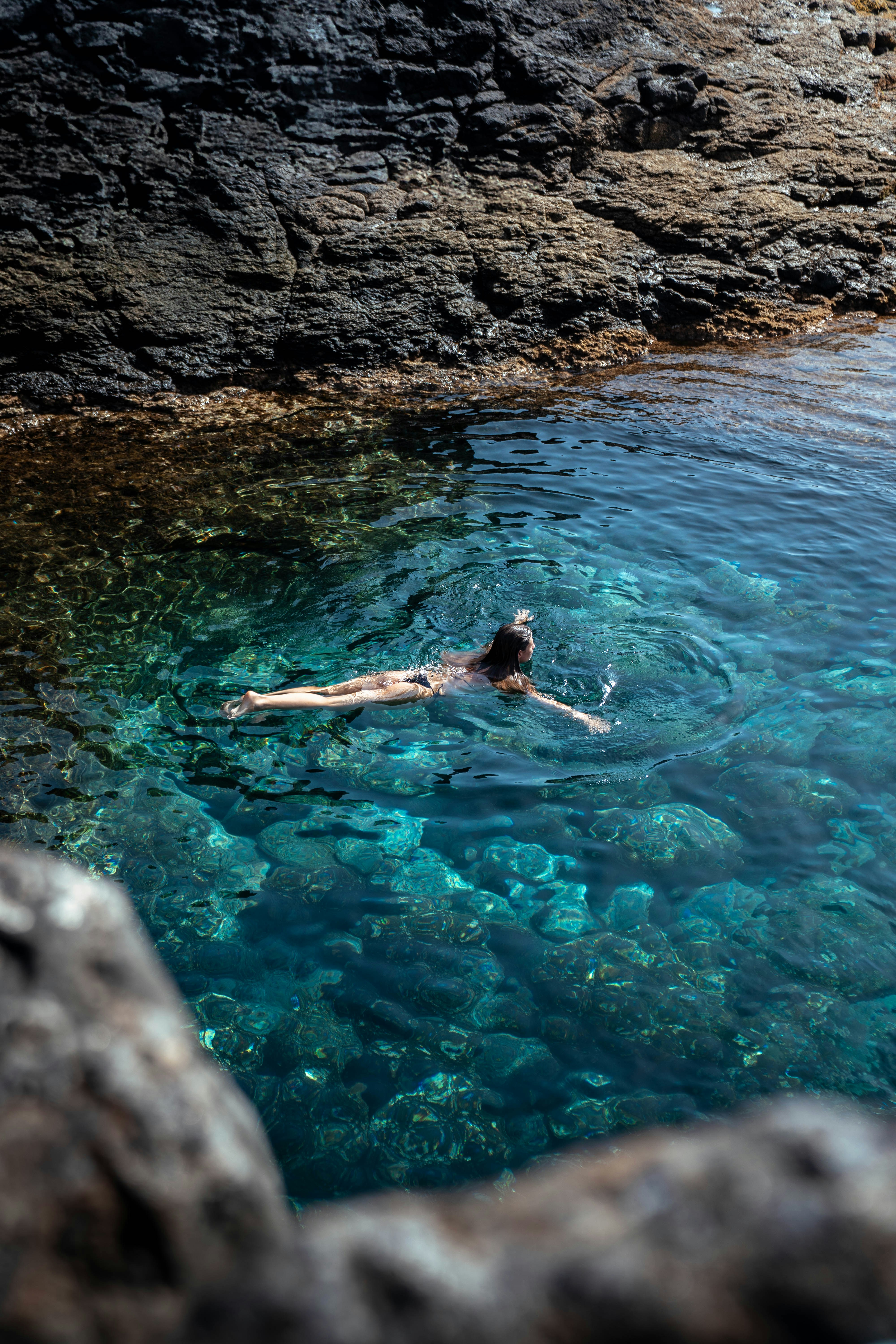 A person swims in beautiful turquoise waters.