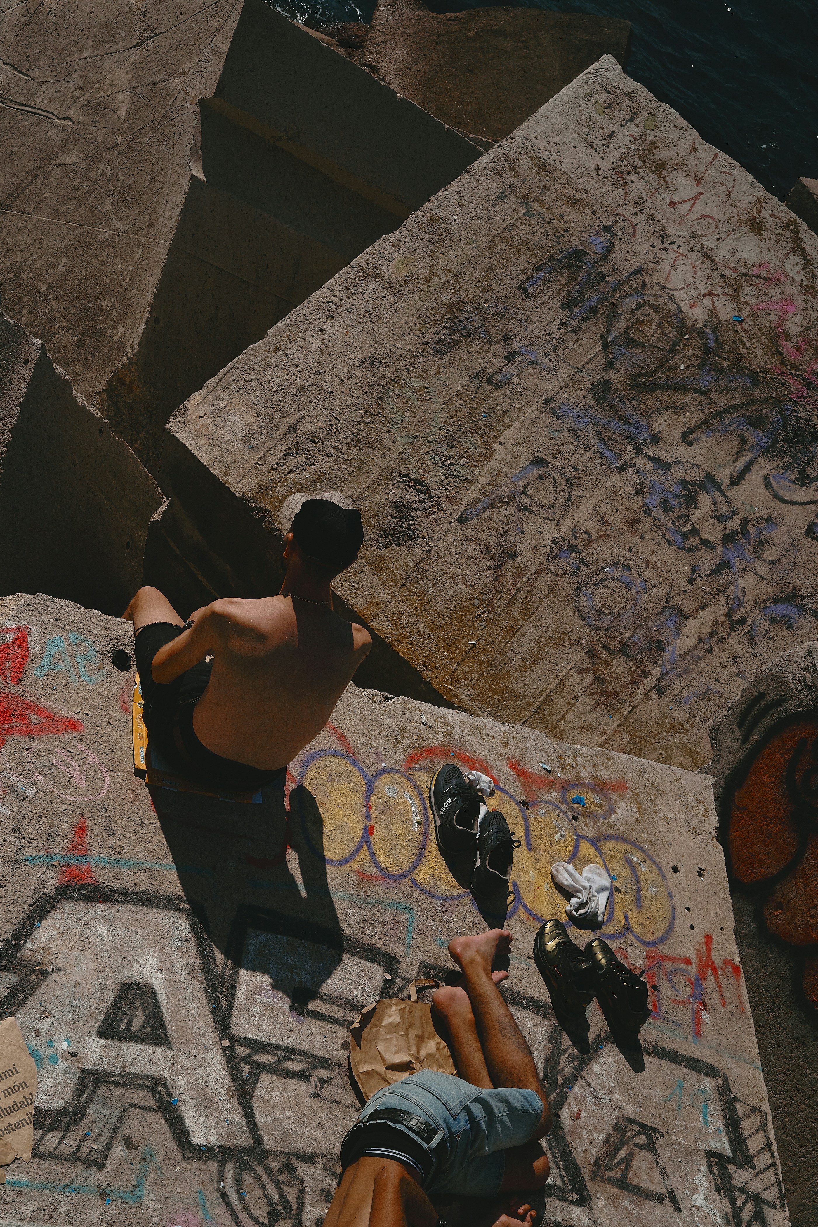 People are hanging out near a graffiti-covered wall.