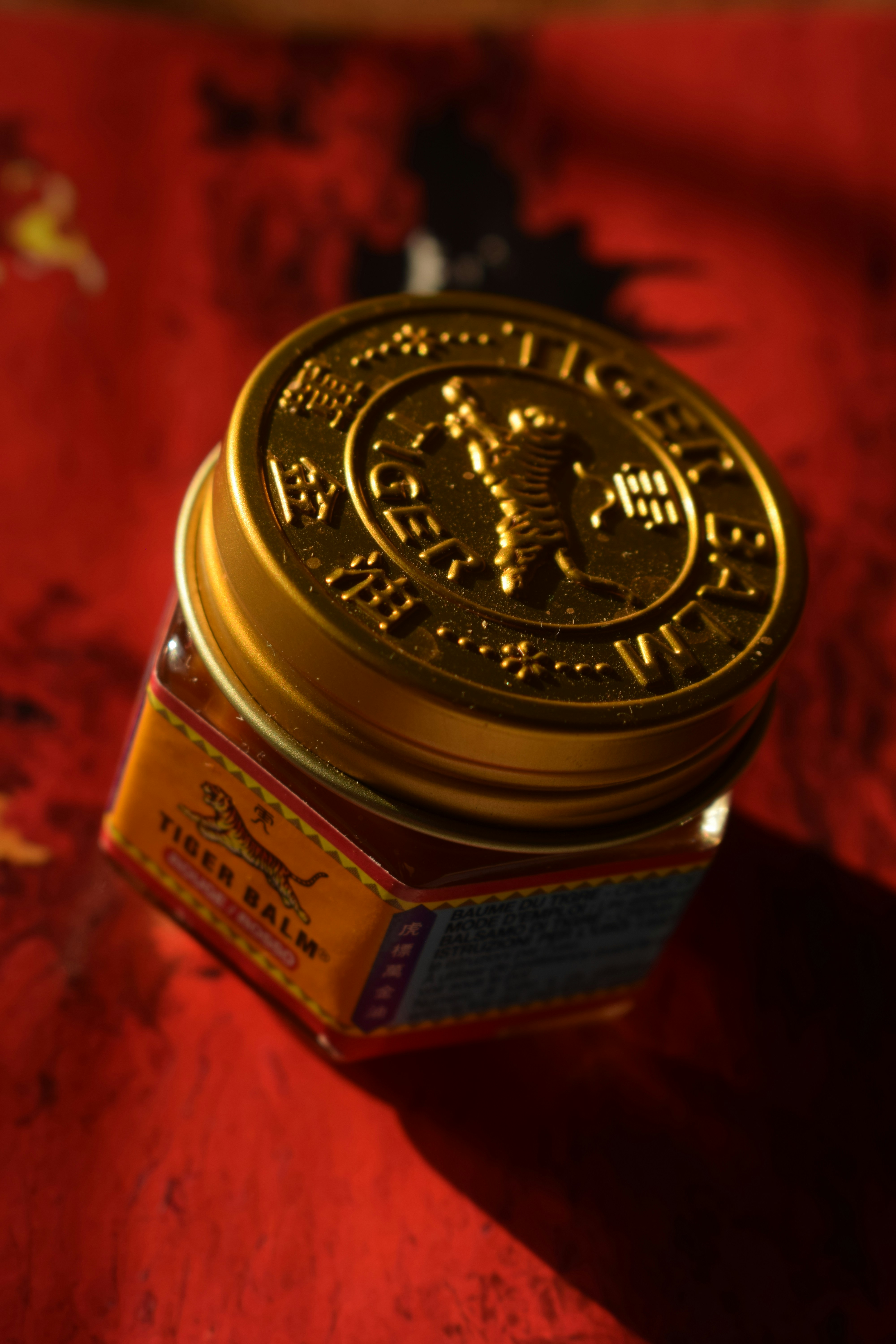 Tiger balm jar, golden and prominently displayed.