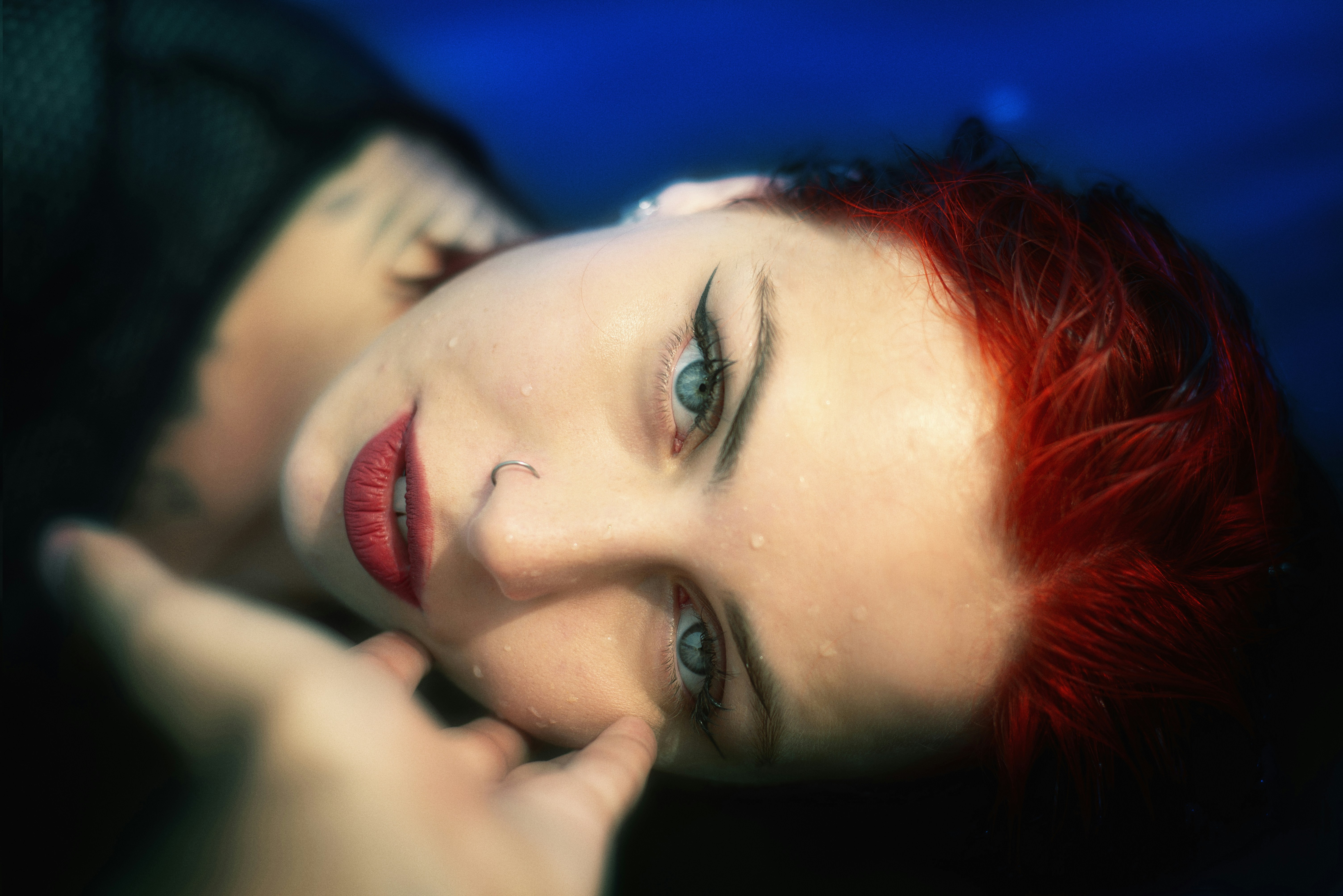 Red-haired woman gazes intensely.