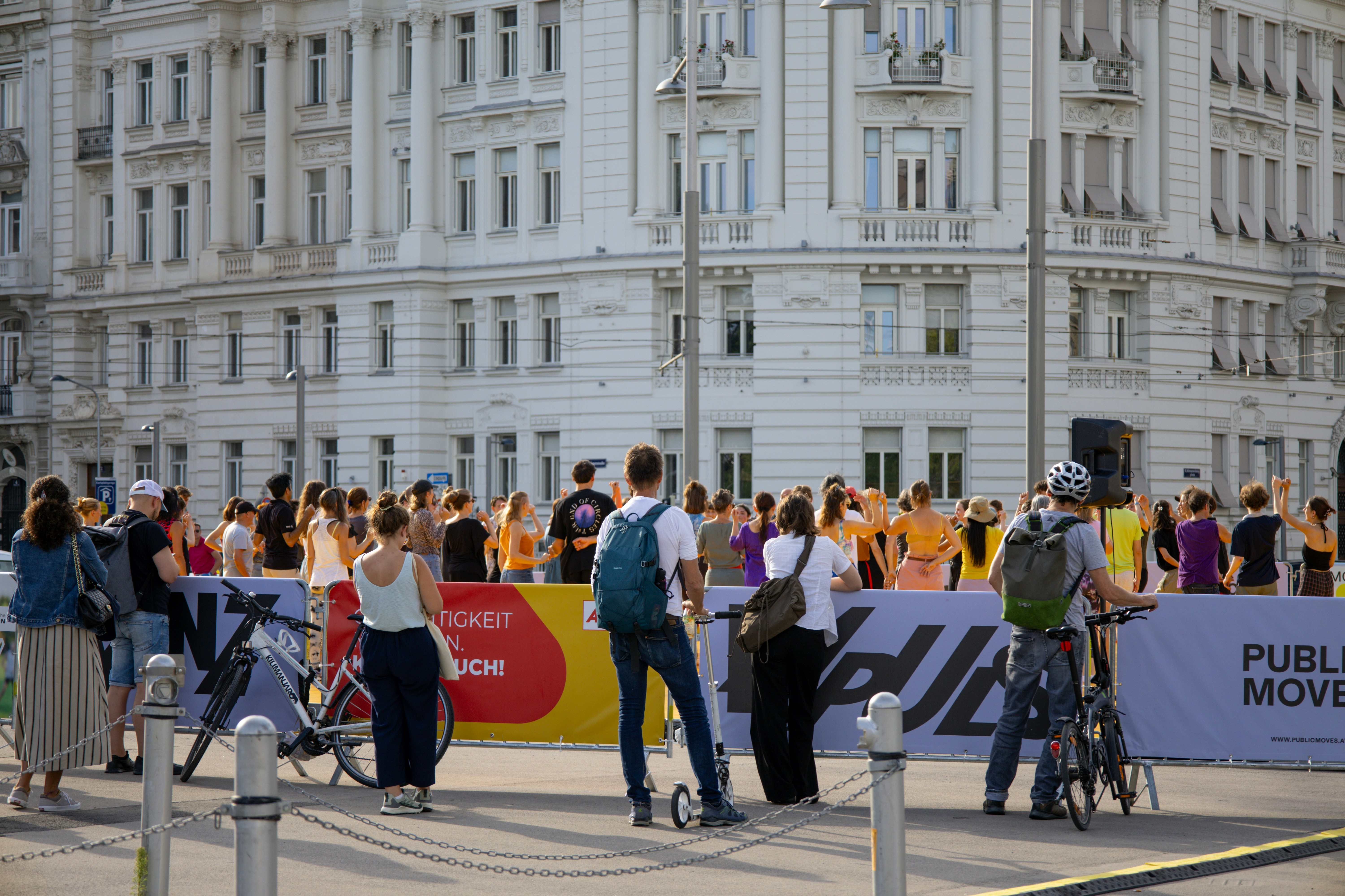 People gather in front of a building in a city.