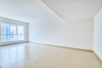 A spacious, empty room with a large window.